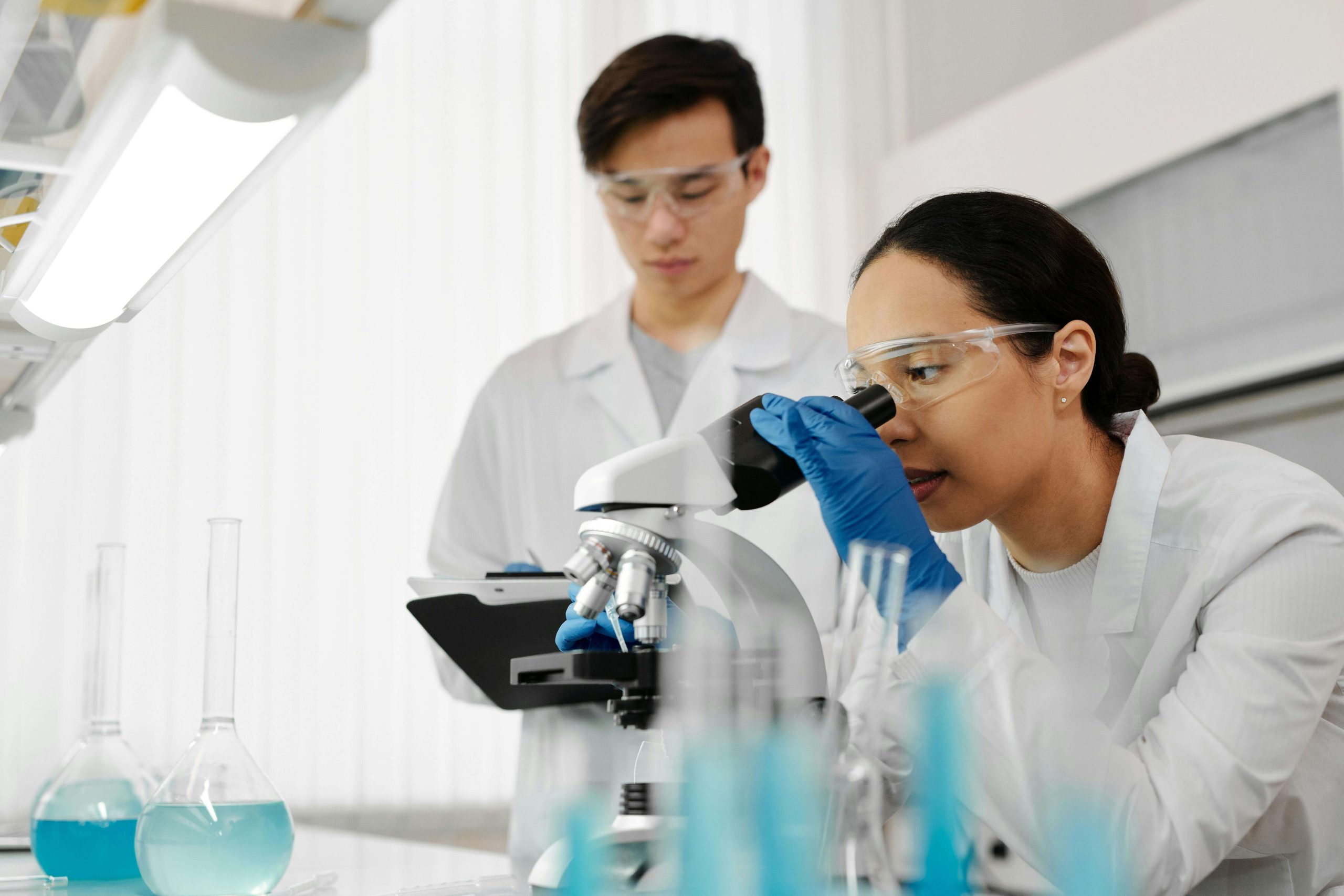Scientists looking through a microscope.